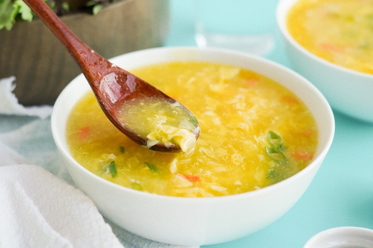 bowl of egg drop soup, wooden spoon