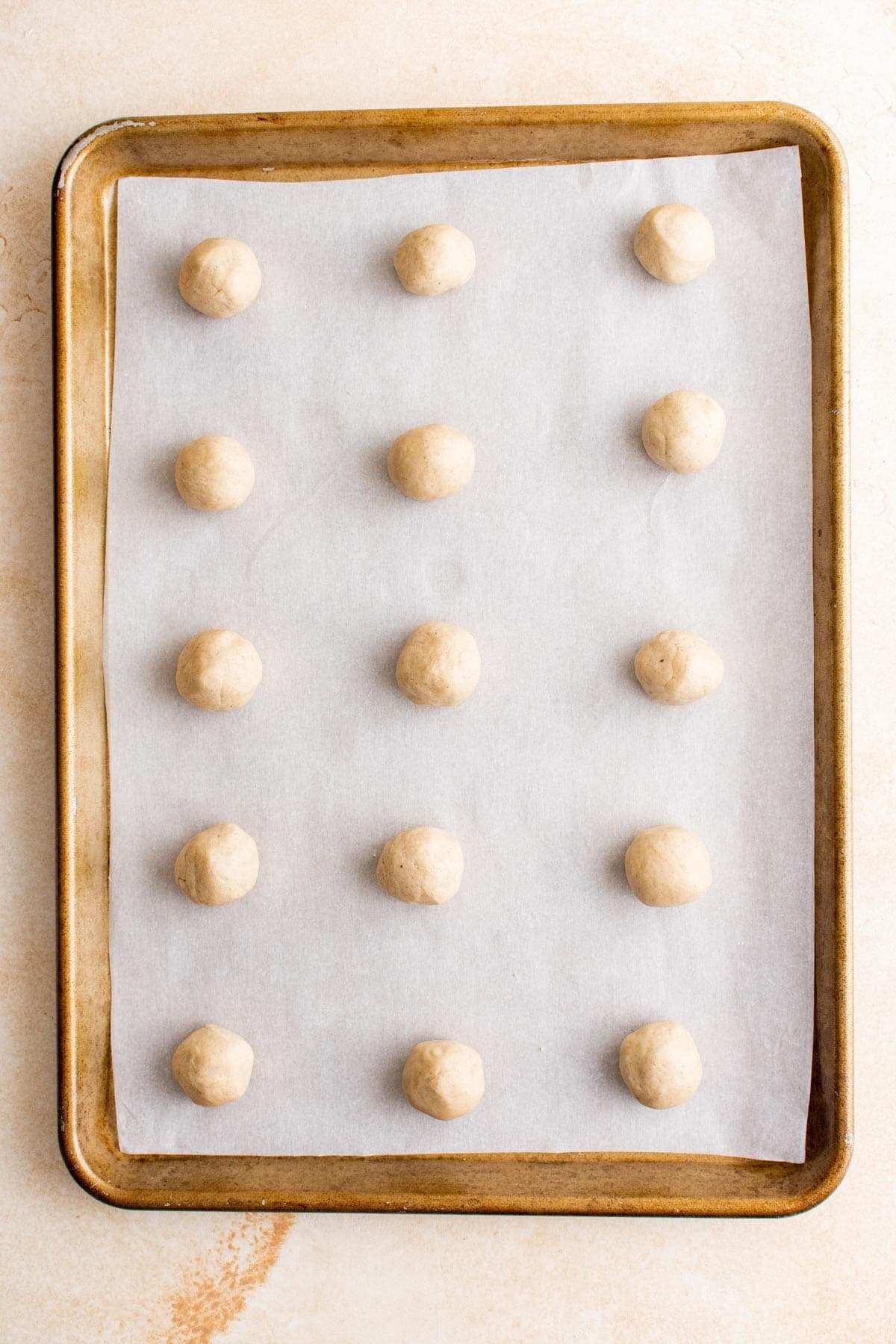 eggnog cookie dough balls lined up on a tray