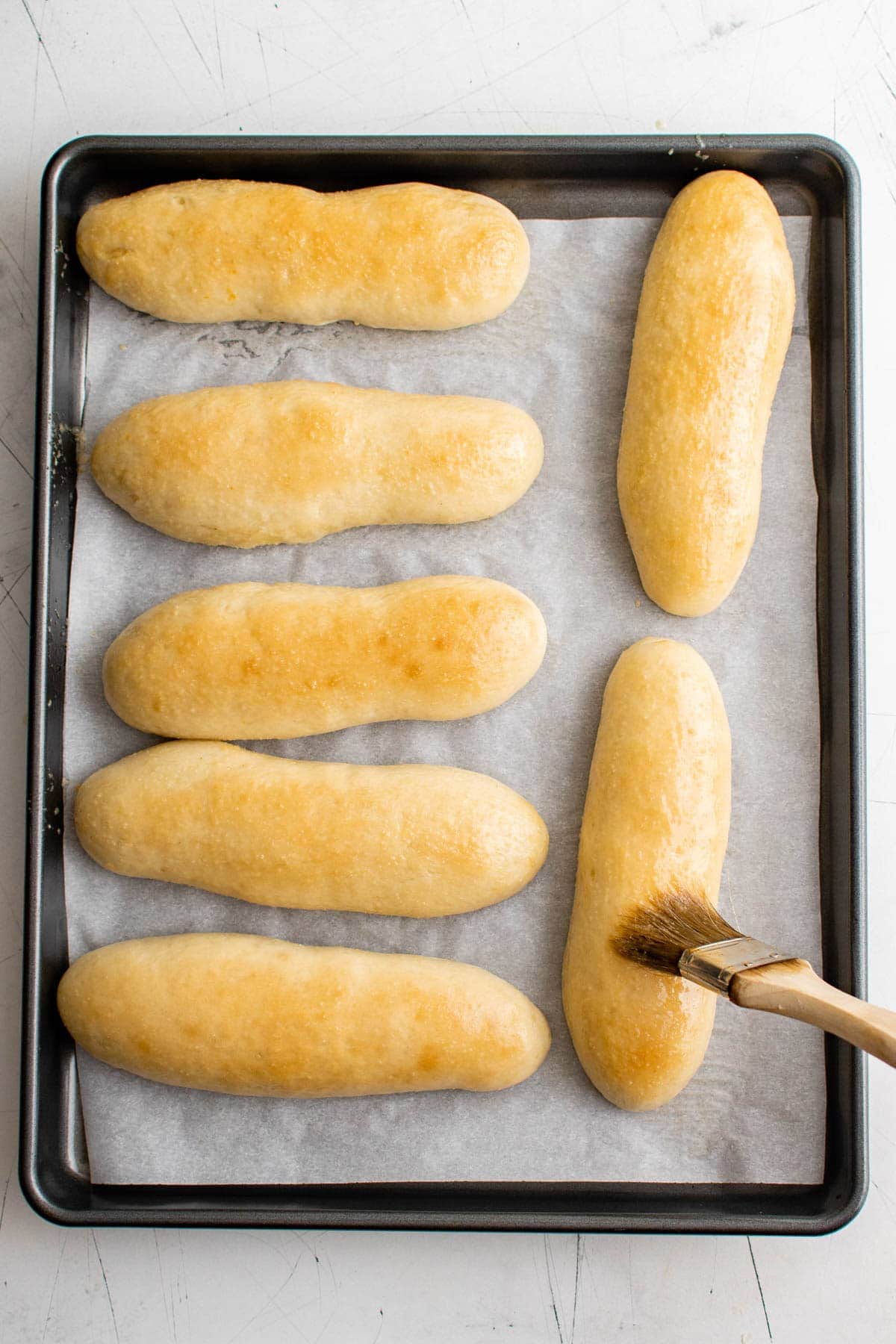breadsticks on a baking sheet, brushed with garlic butter