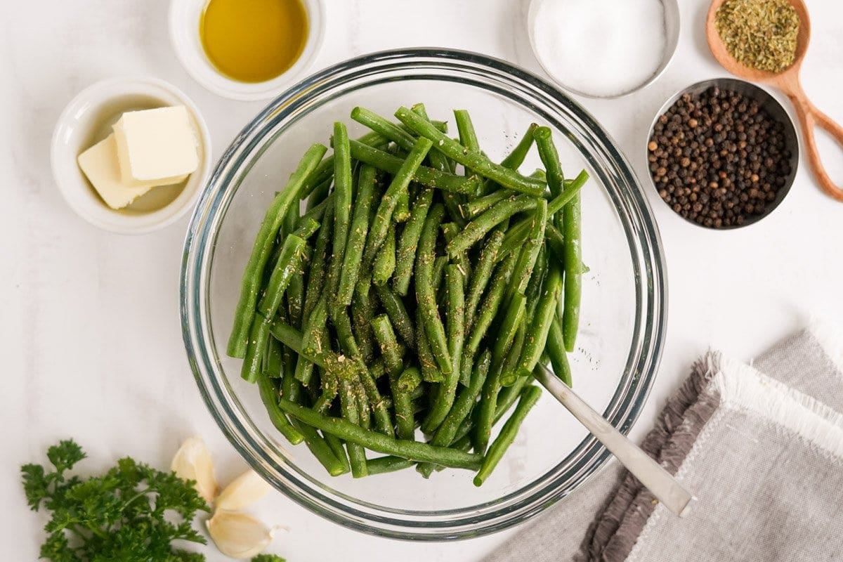 green beans with olive oil, salt and pepper in a bowl