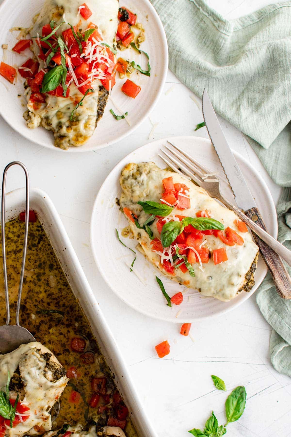 plates with baked chicken pesto and tomatoes