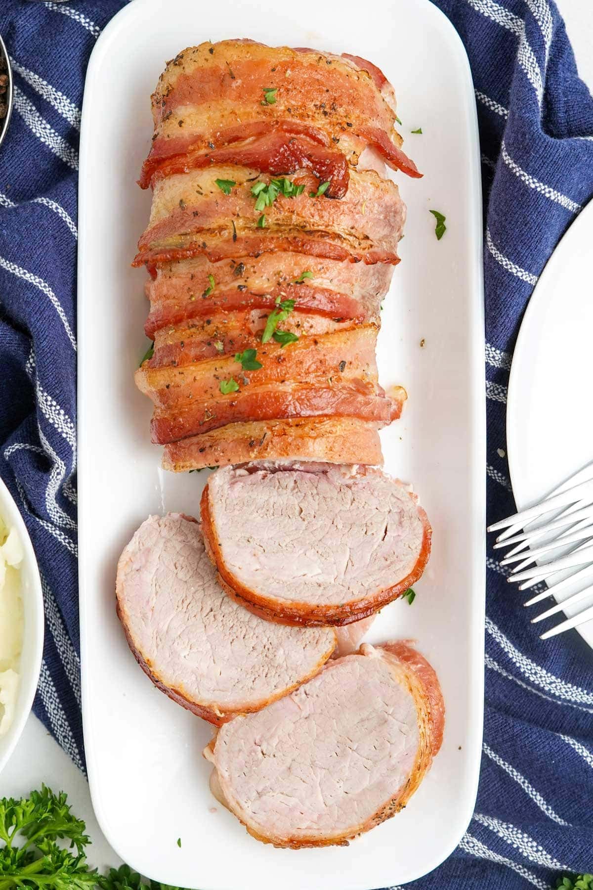 overhead shot of bacon wrapped pork tenderloin on a platter