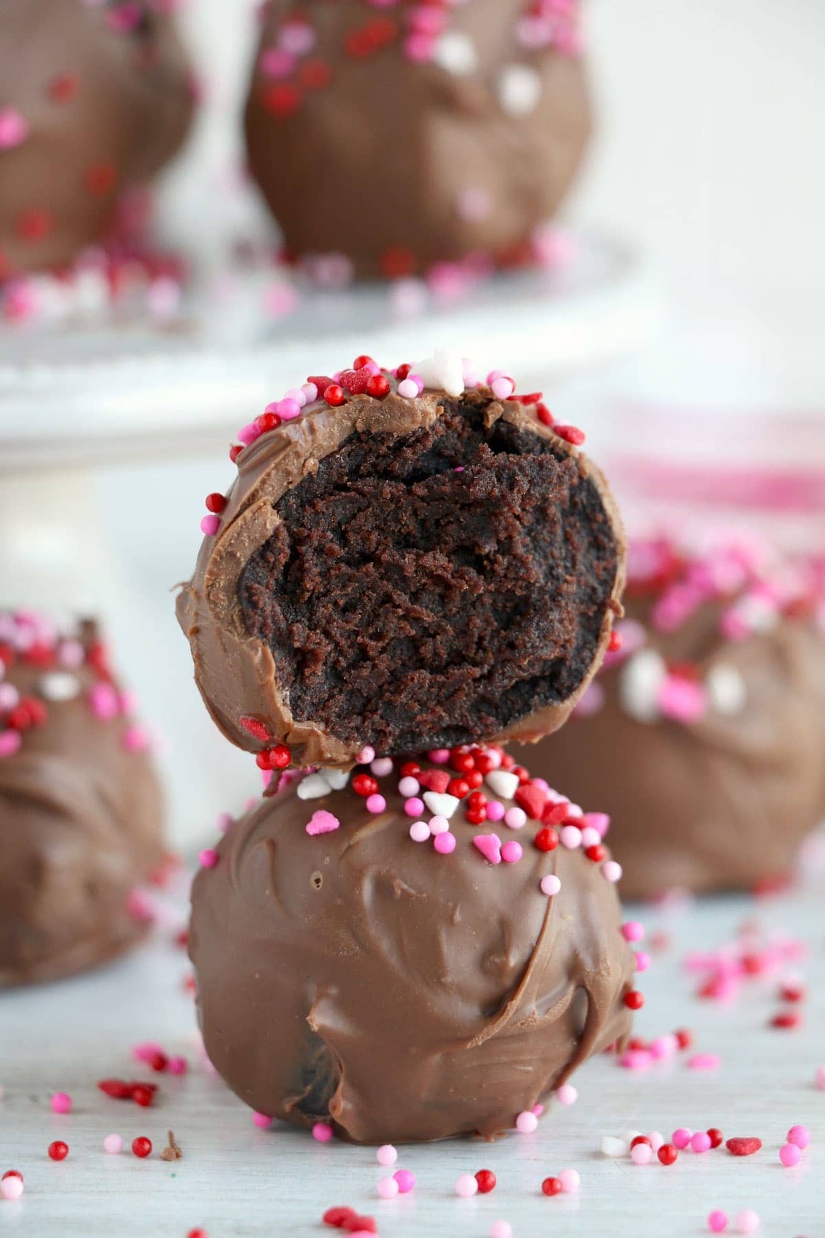 a cake ball, split in half to reveal the insides, stacked on top of another chocolate cake ball