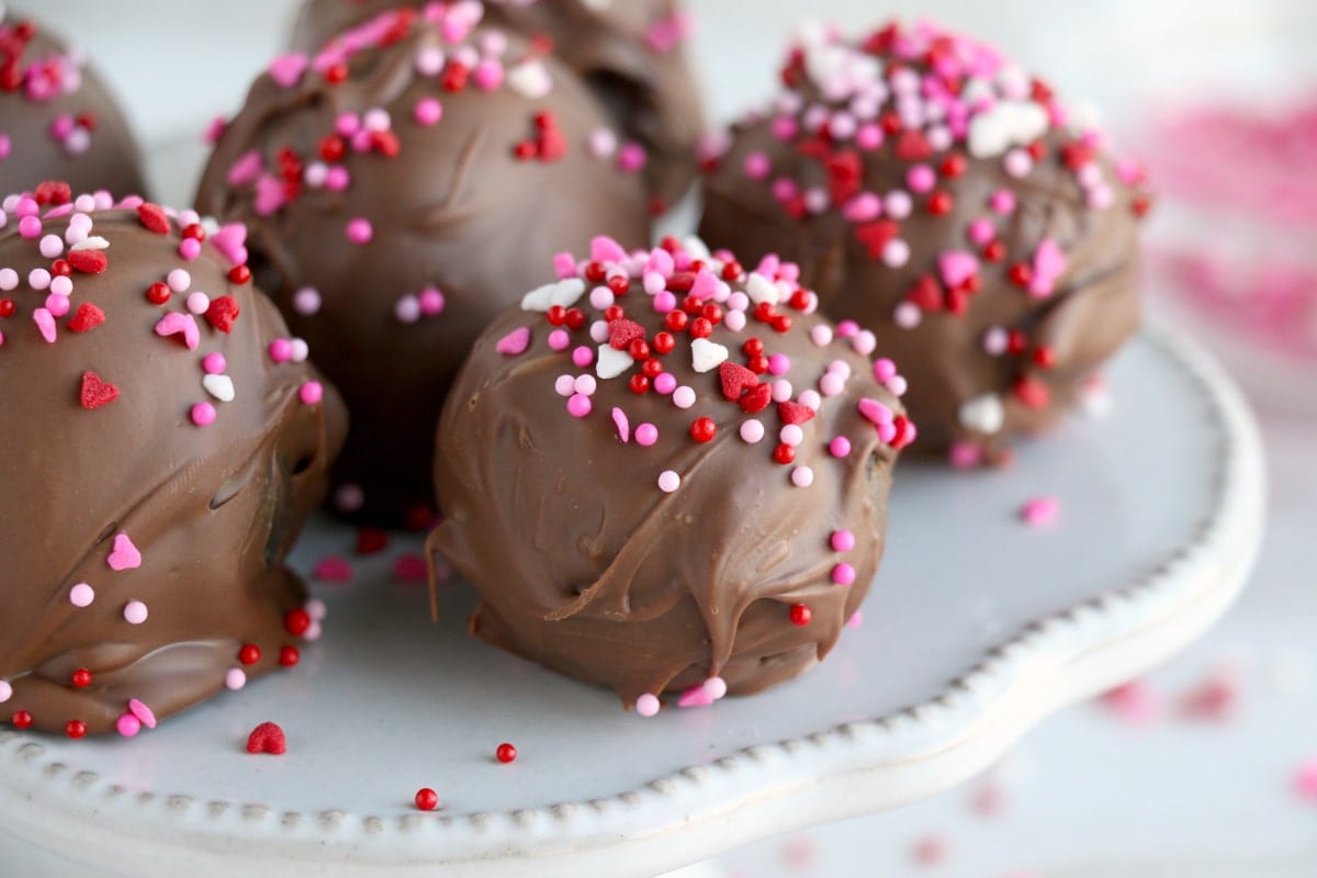 chocolate cake balls with sprinkles on a cake plate
