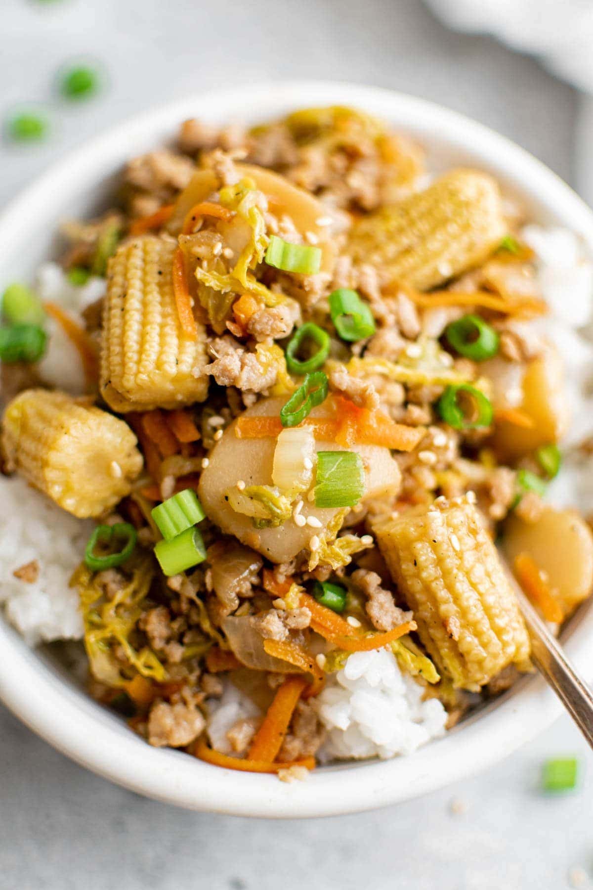 close up of ground pork stir fry in a bowl over rice