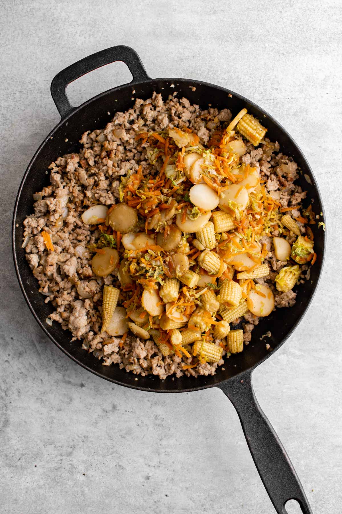 stir fry ground pork and vegetables in a skillet