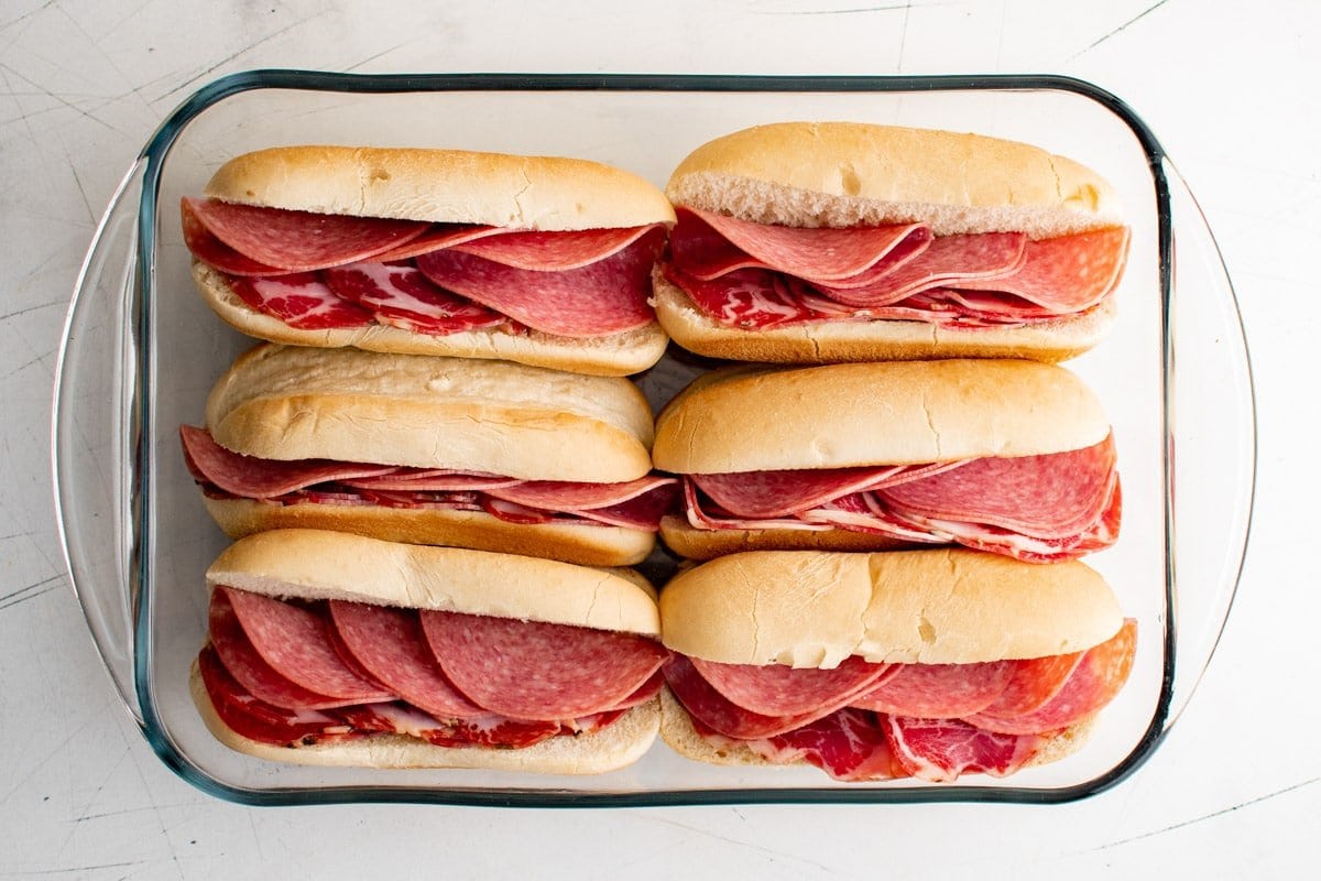 hoagie rolls in a baking dish with salami