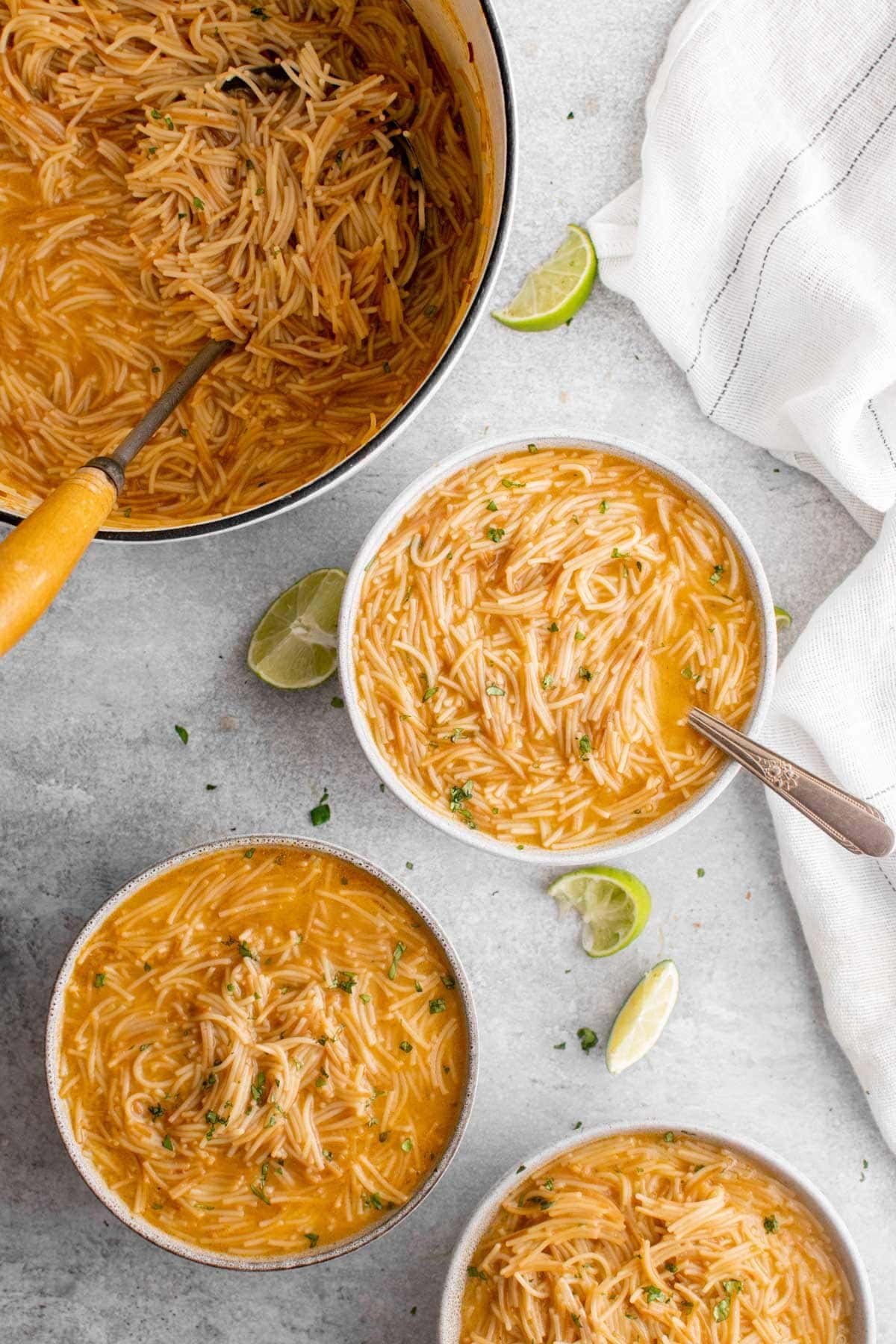 bowls of mexican noodle soup with spoons