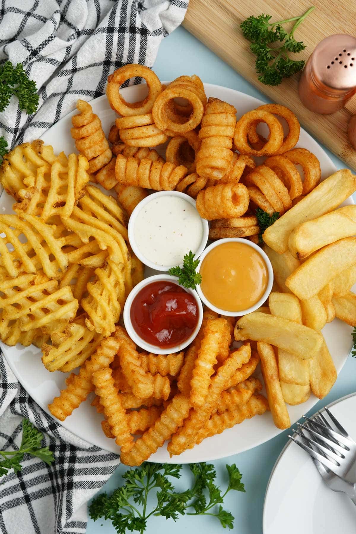 different types of french fries on a platter with dipping sauces
