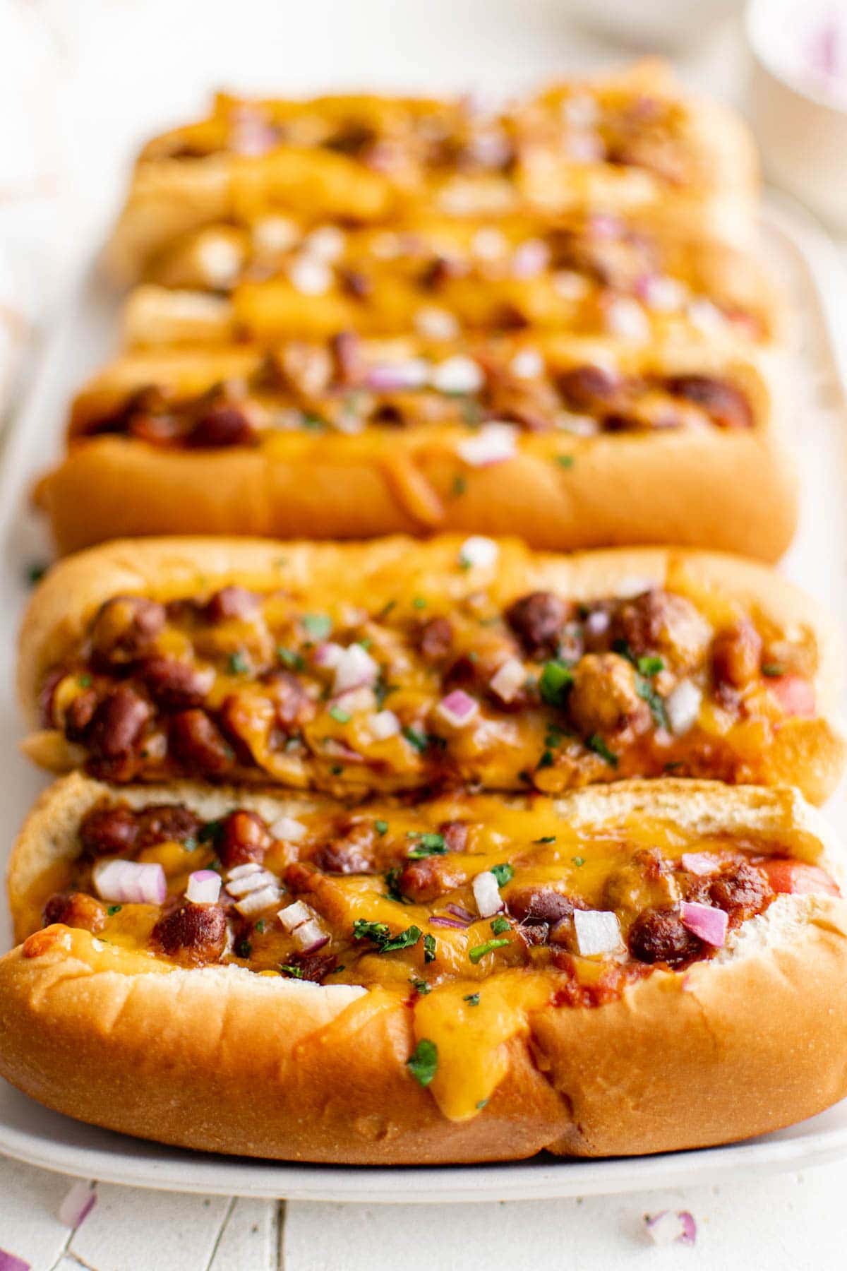 chili cheese dogs on a whilte platter
