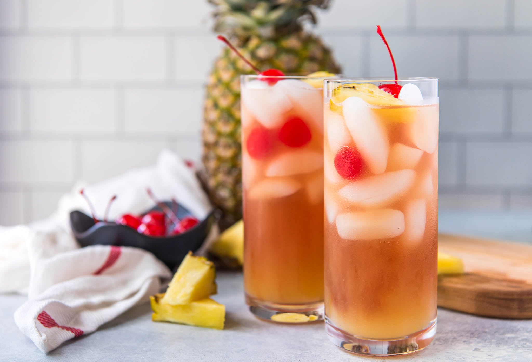 Two malibu bay breeze cocktails garnished with pineapple and cherries