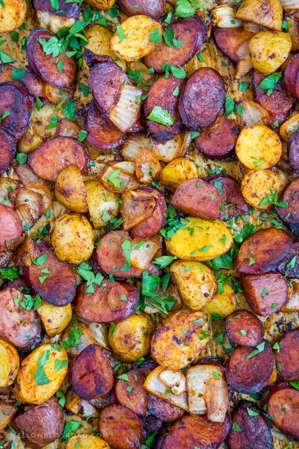 sausage, potaotes and onions cooked on a sheet pan