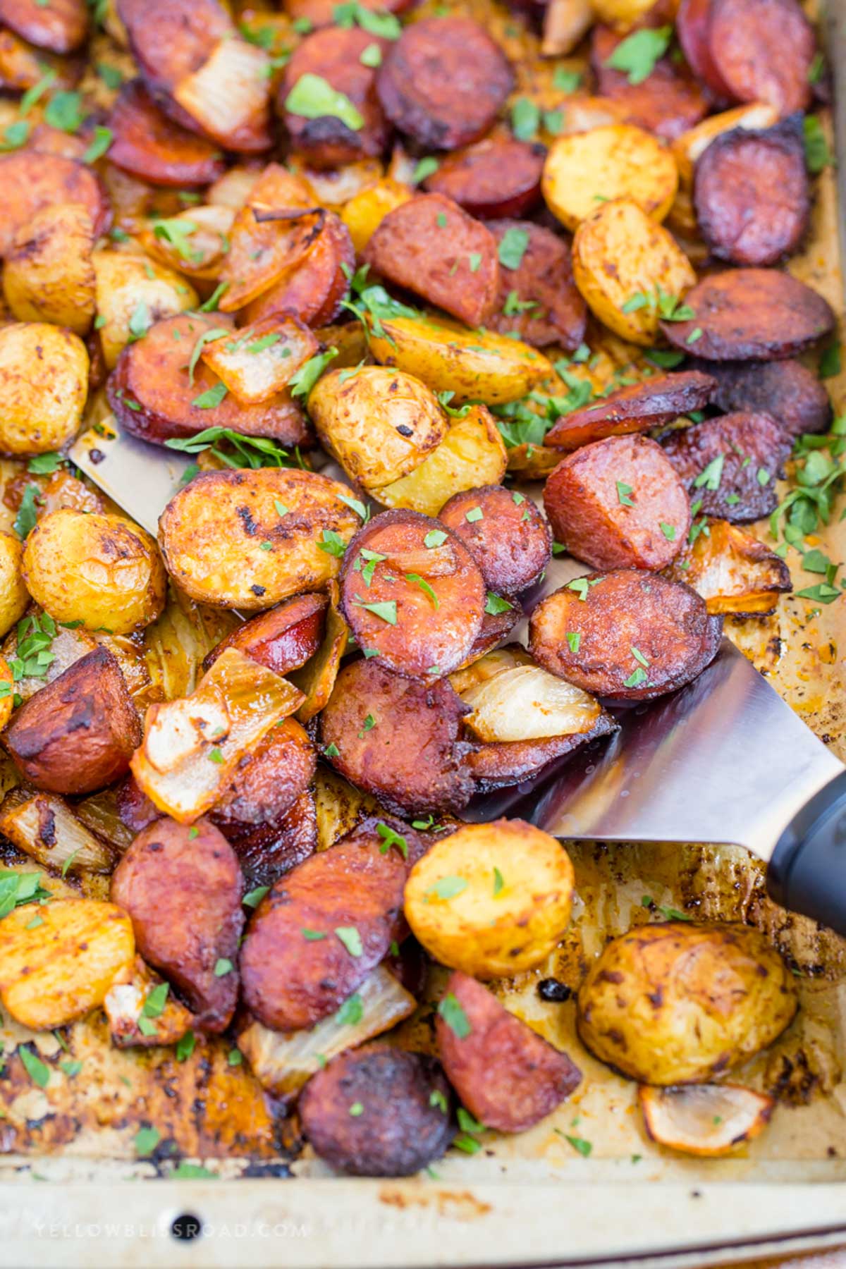 spatula scooping sausage and potatoes