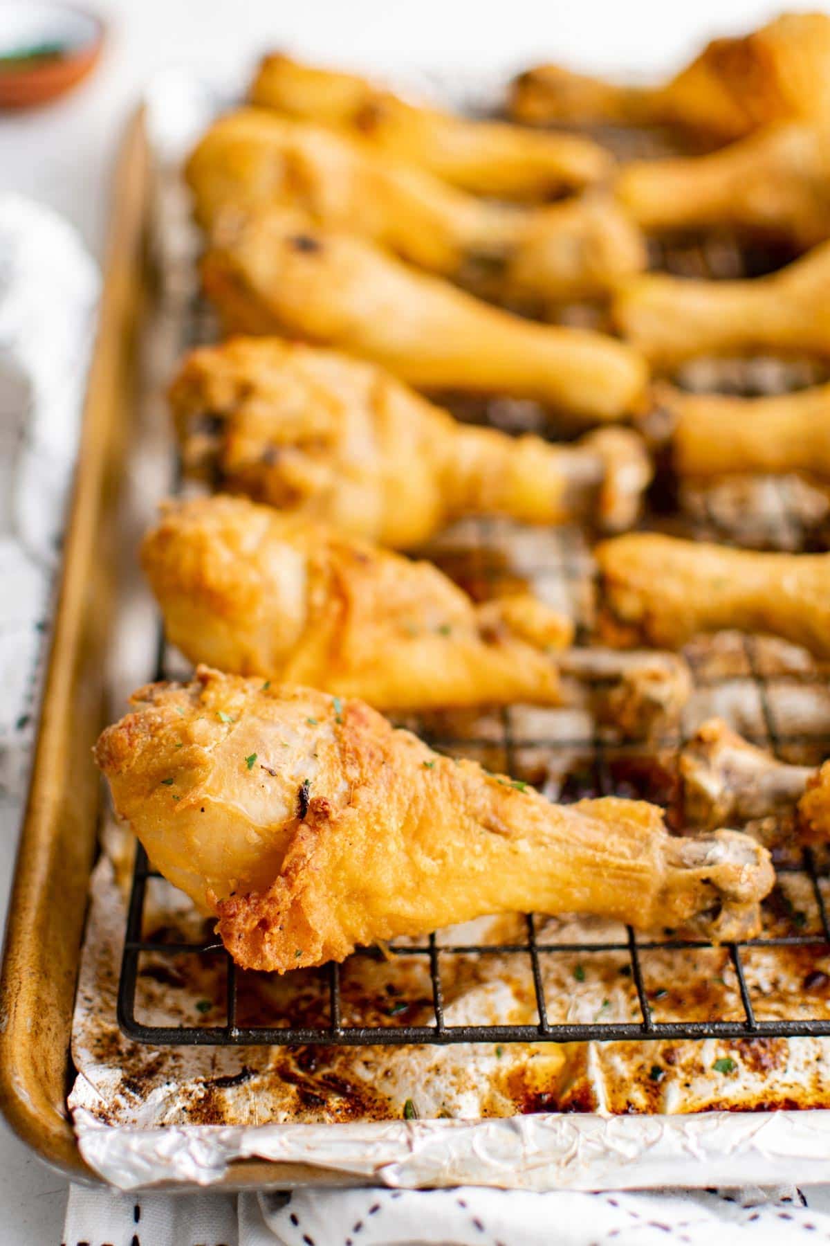 close up of chicken drumsticks on baking rack