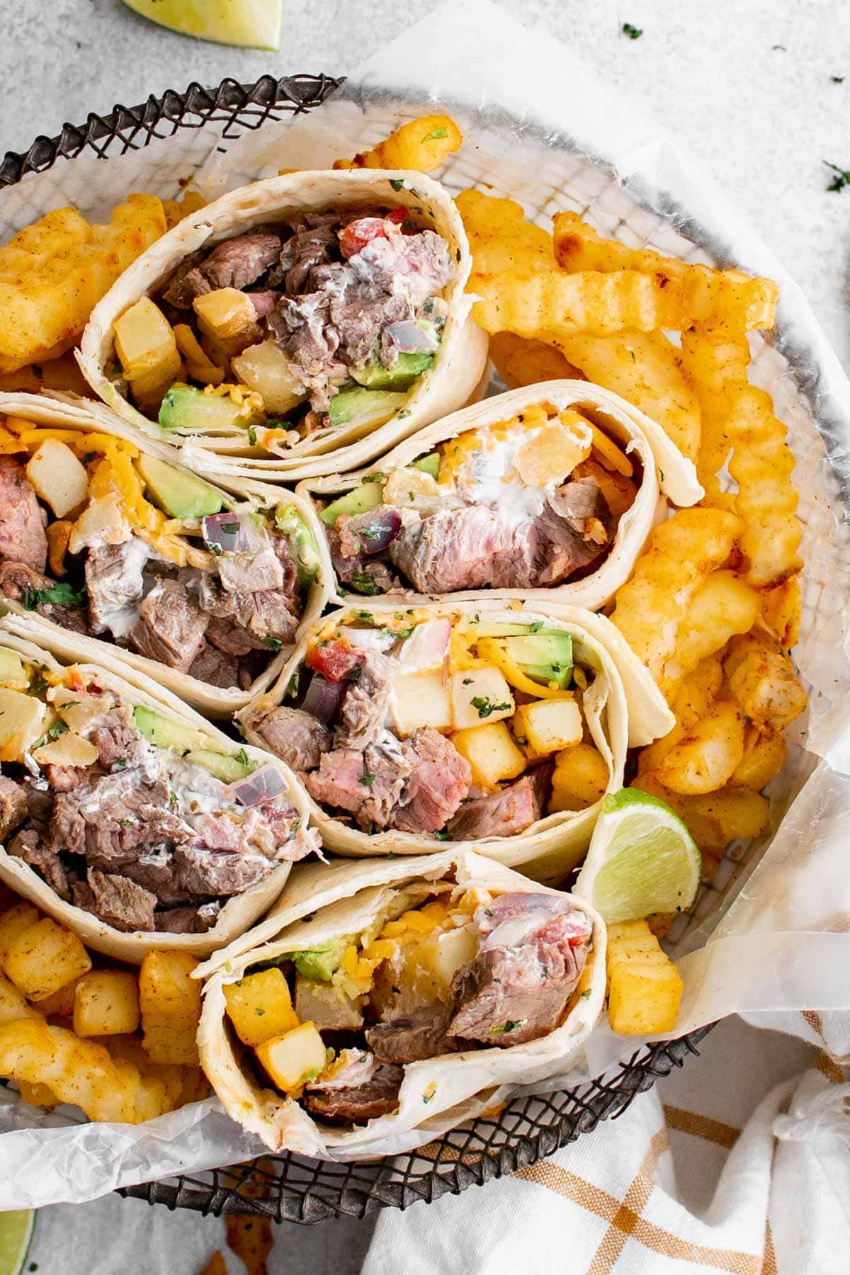 california burritos, cut in half to expose the insides, in a basket of fries