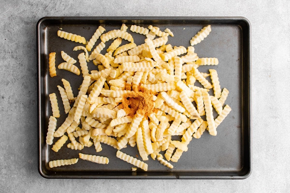 frozen fries on a baking sheet with taco seasoning