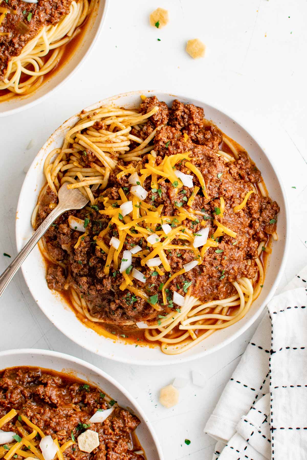 plate of spaghetti with cincinnati chili and cheese and onions