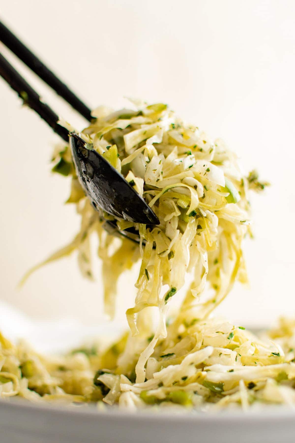 cabbage salad served from a bowl with tongs