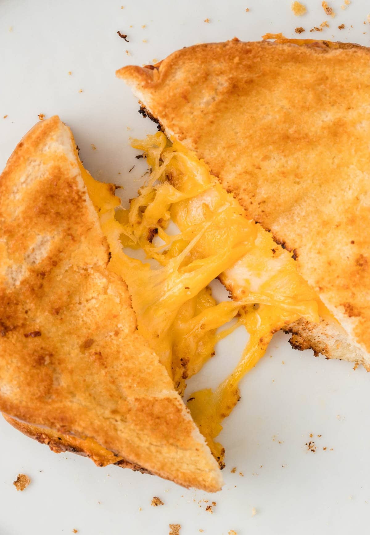 up close image of a grilled cheese with stringy cheese pull