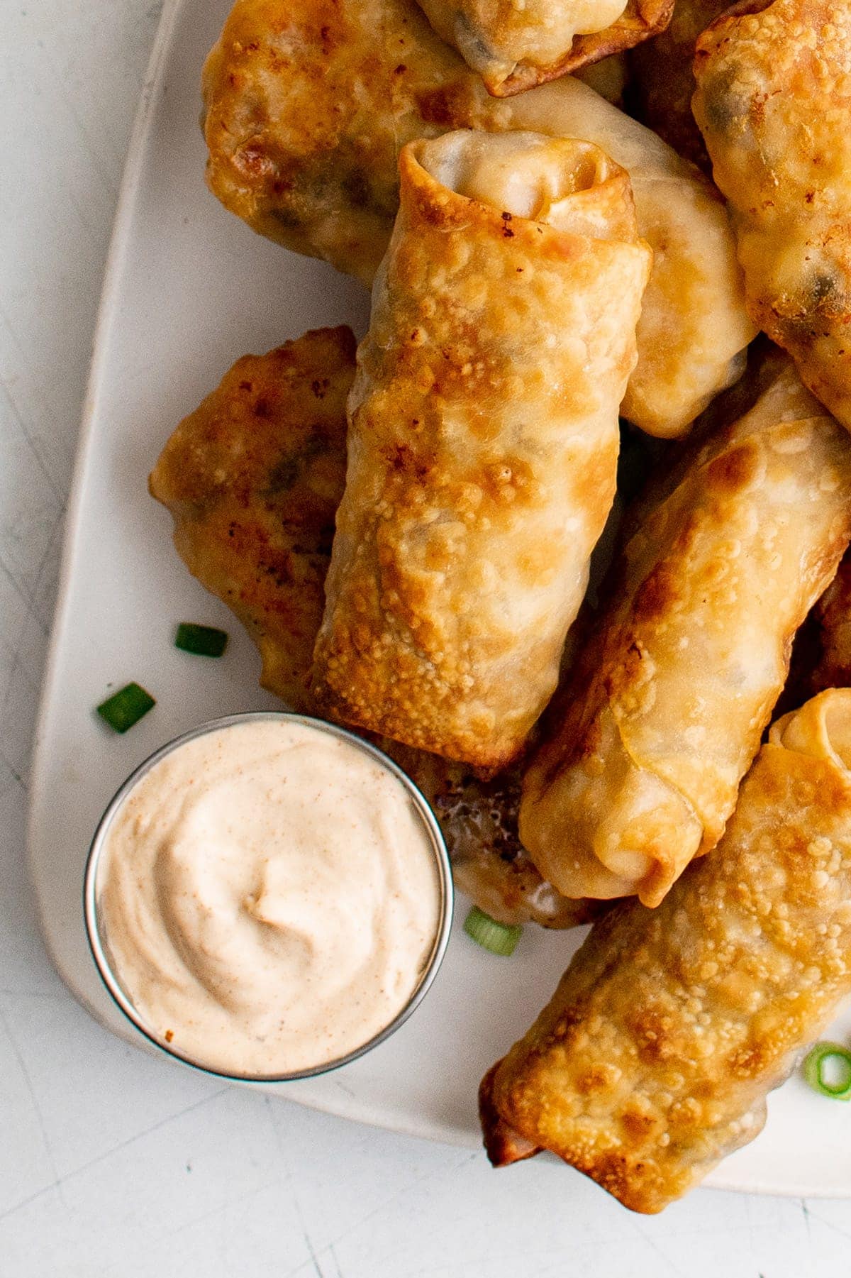 egg rolls on a platter with a zesty dip