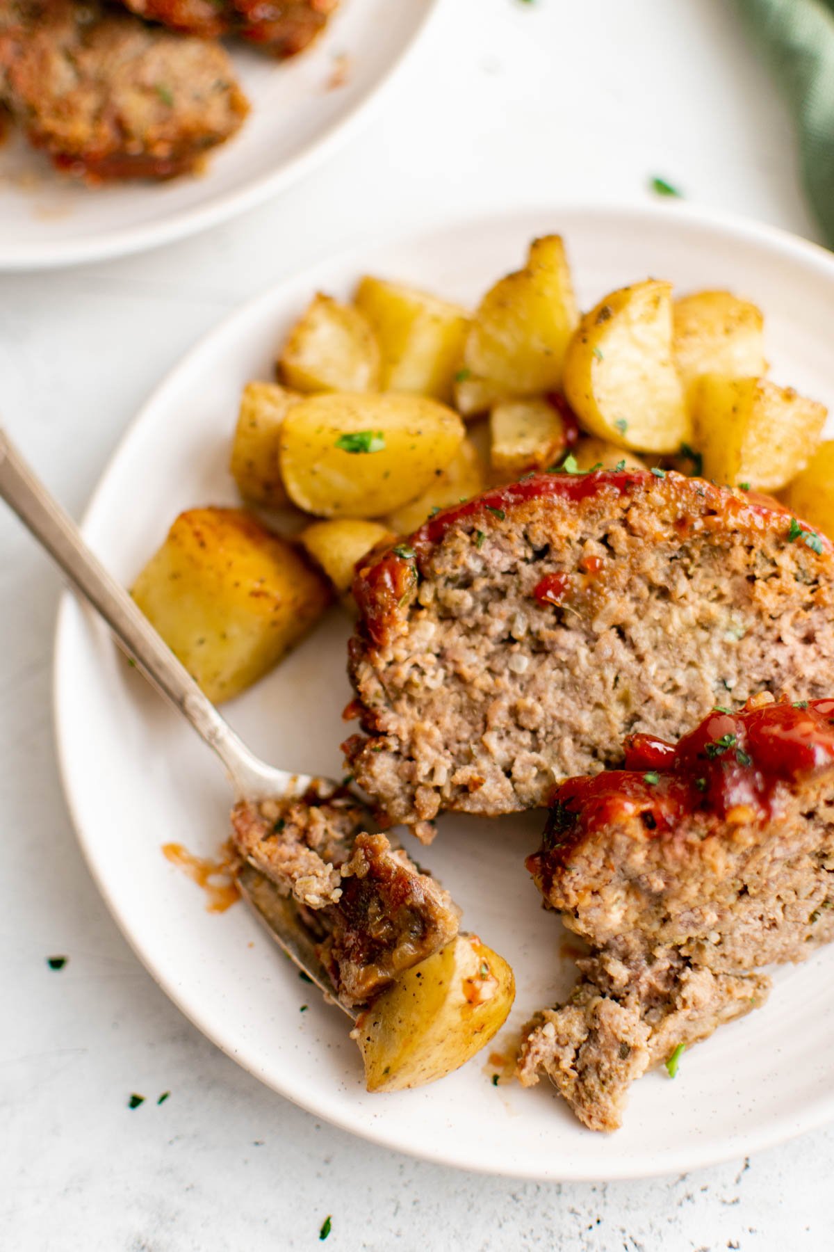meatloaf and roasted potatoes on a plate with a fork