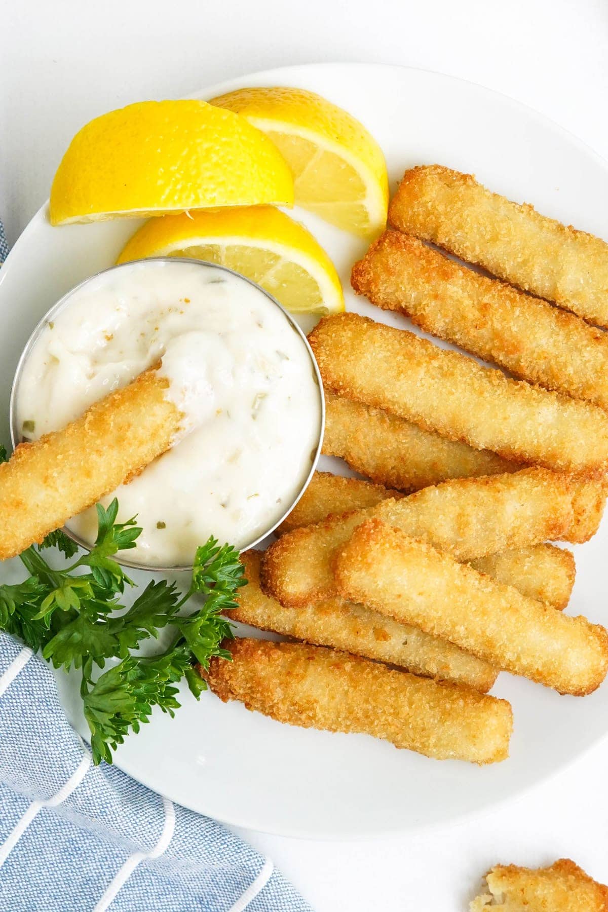 fish sticks on a plate with a dish of tartar sauce