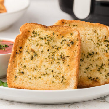 Stack of garlic Texas toast on a white plate