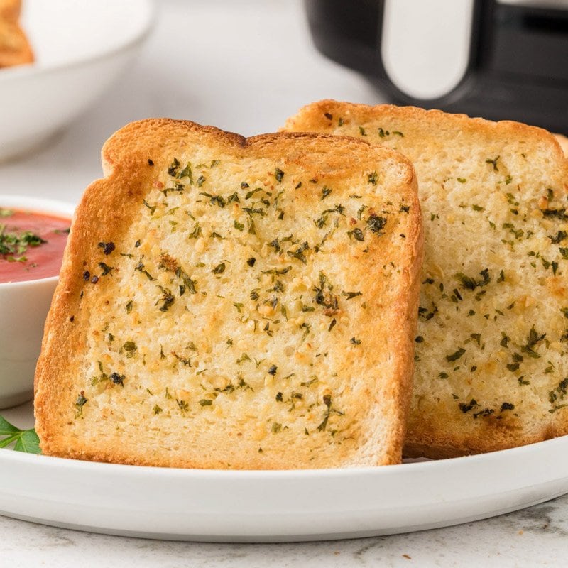 Stack of garlic Texas toast on a white plate  