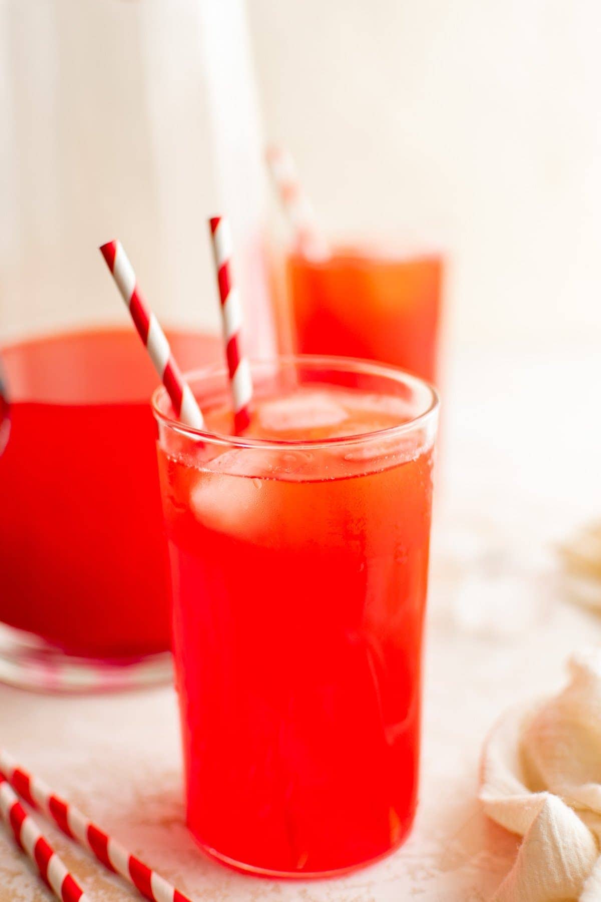 Red Punch in glasses with red and white striped straws.