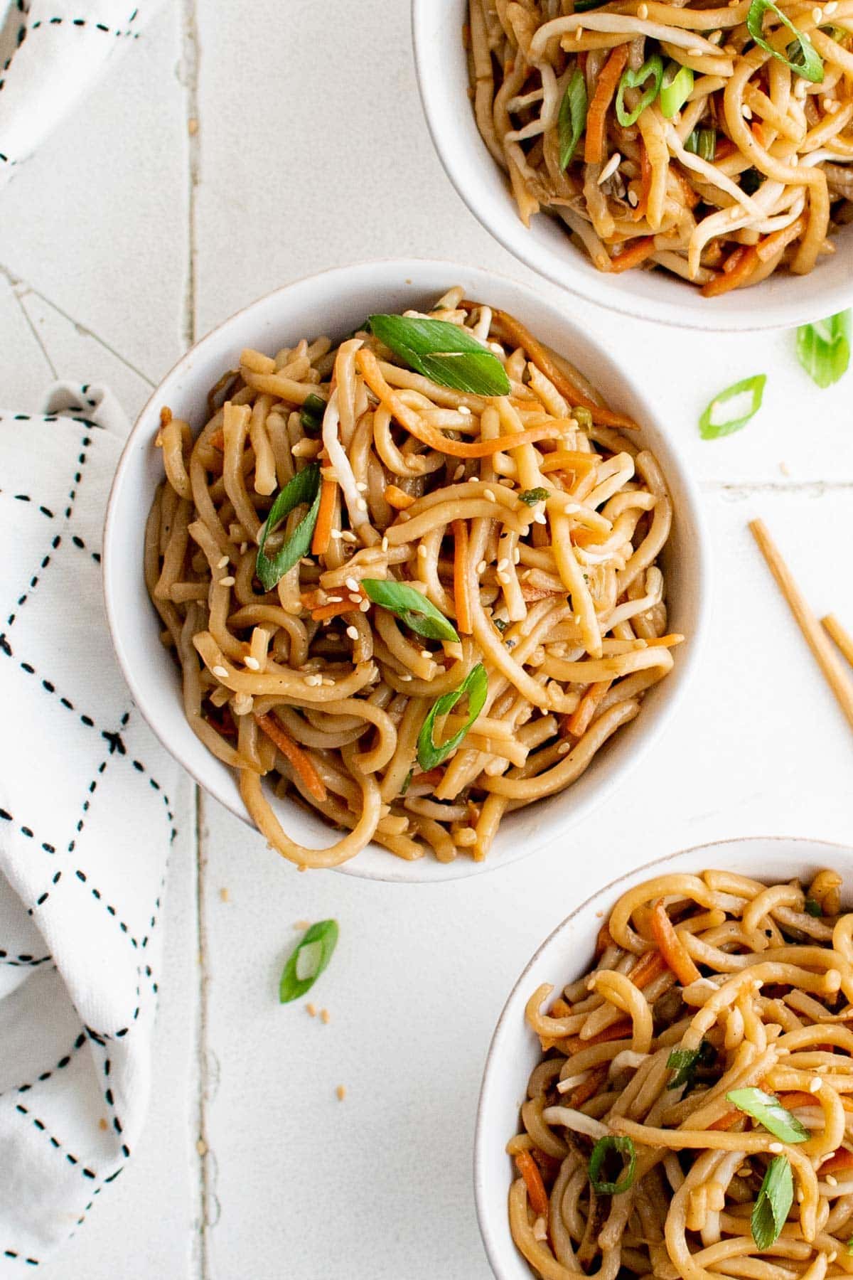 Small white bowls with pan fried noodles.