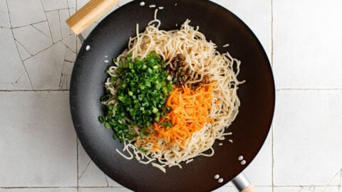 Wok with yakisoba noodles, carrots and green onions.