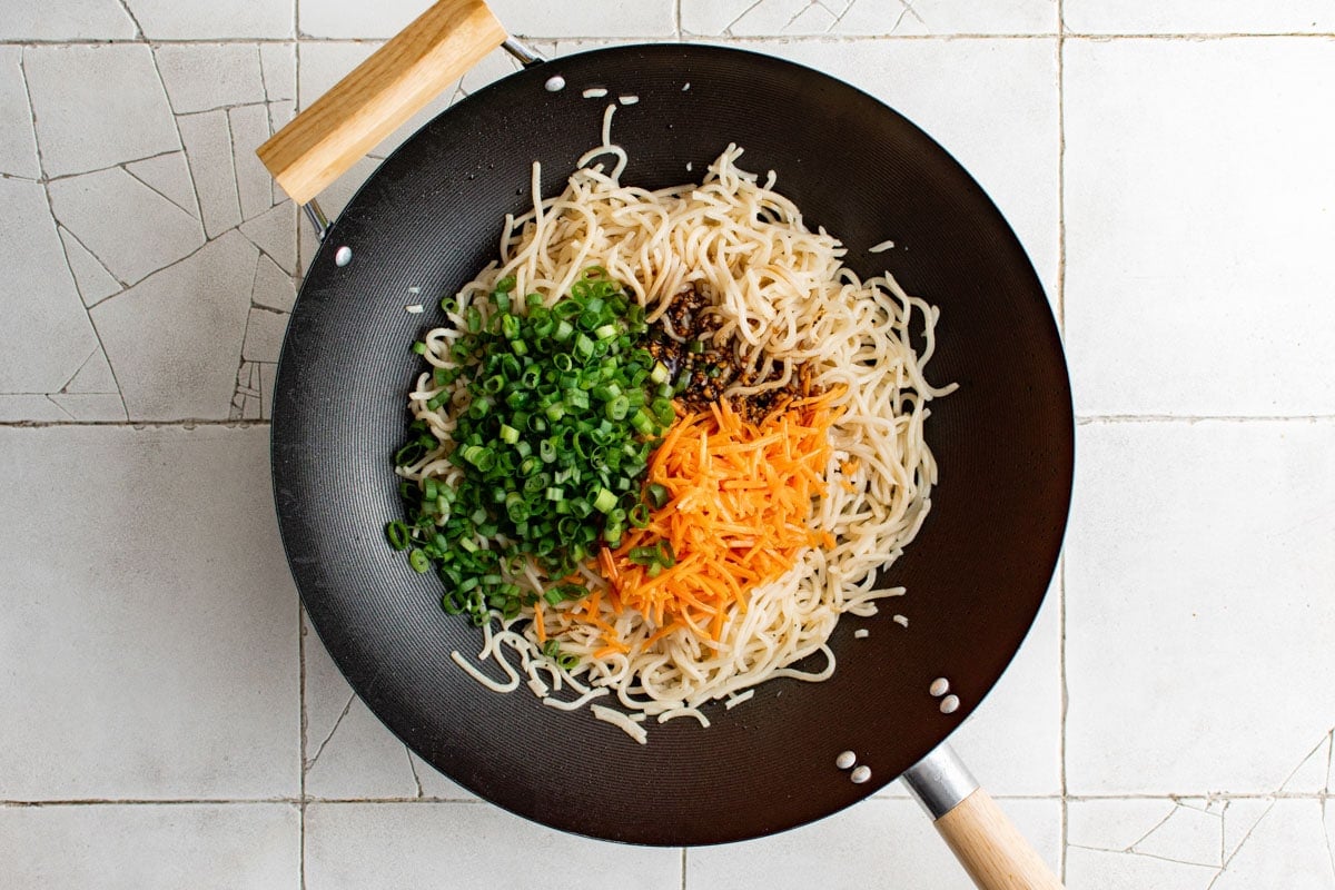 Wok with yakisoba noodles, carrots and green onions.