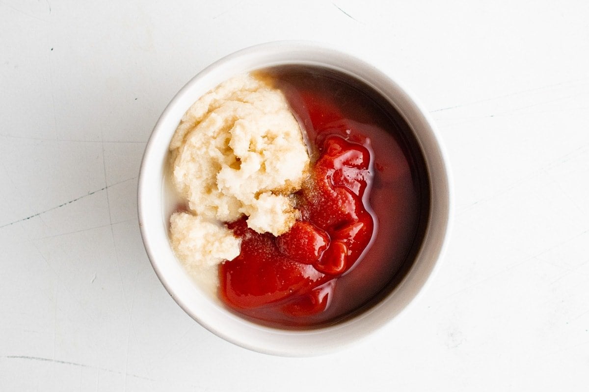 Ketchup and horseradish in a white dish. 