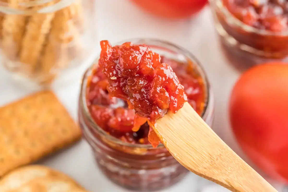 Tomato jam on a small wooden knife.