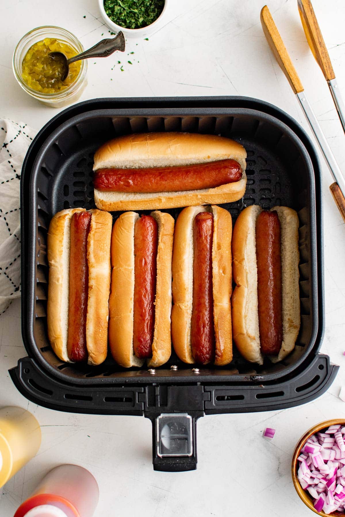 Air fryer hot dogs in an air fryer basket.