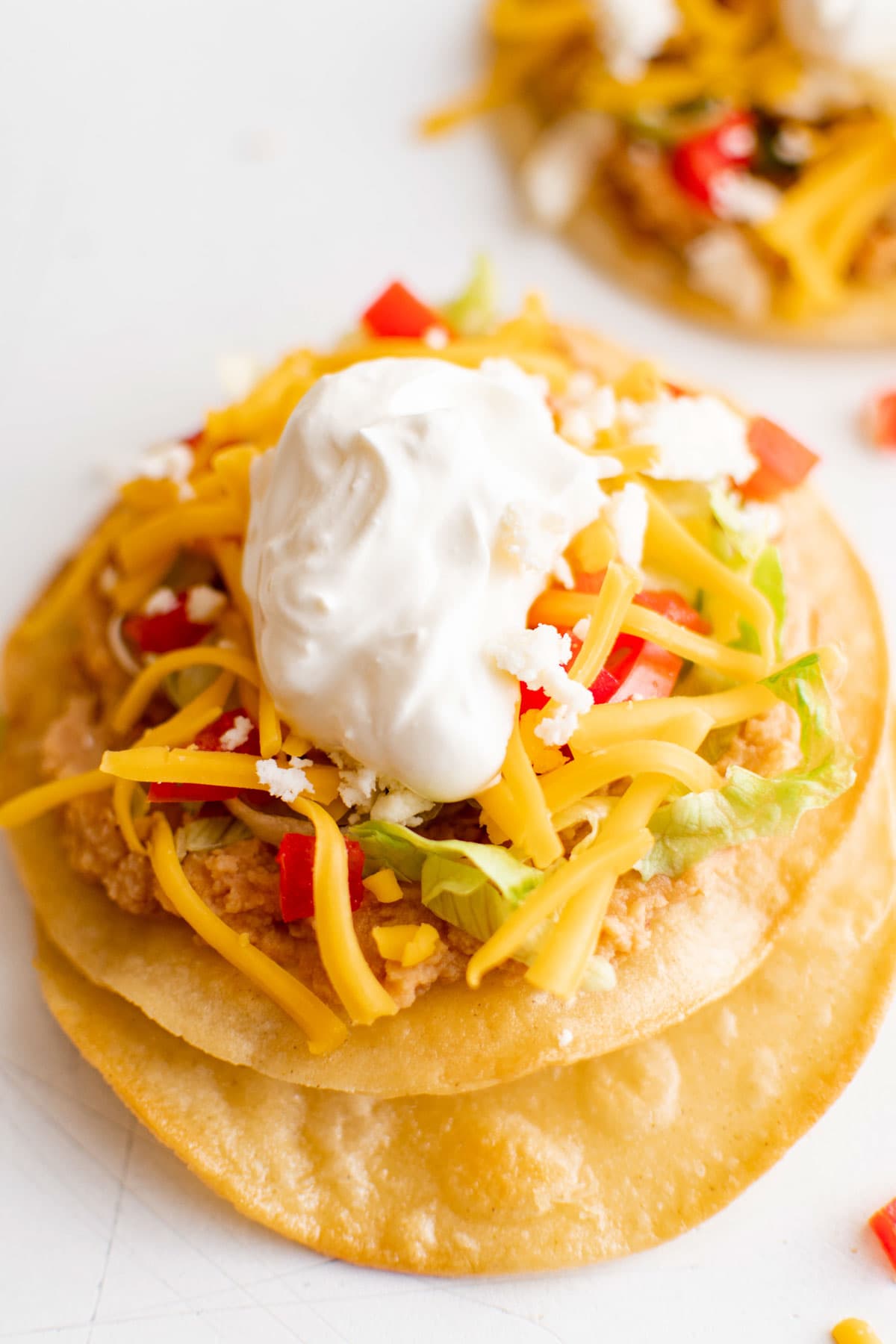 Baked tostada shell with beans, cheese and sour cream toppings.