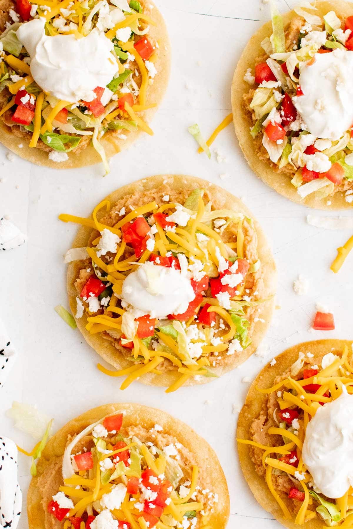 Tostadas with beans, lettuce, cheese and sour cream.