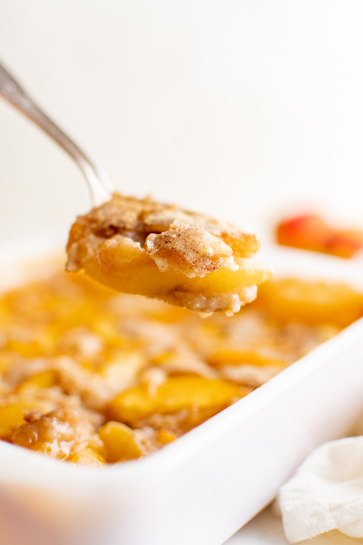 Spoon with peach cobbler. 