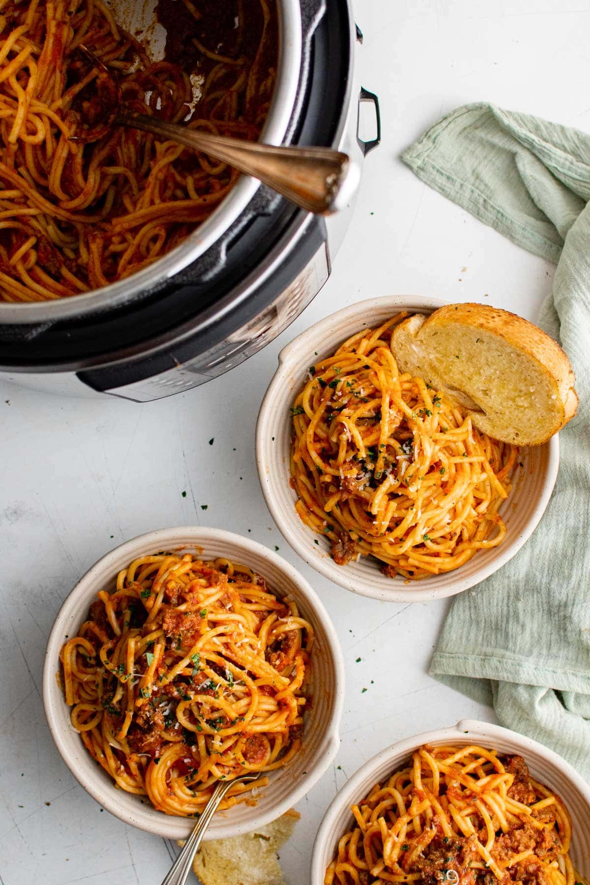 Bowls of spaghetti with meat sauce, bread and na instant pot.
