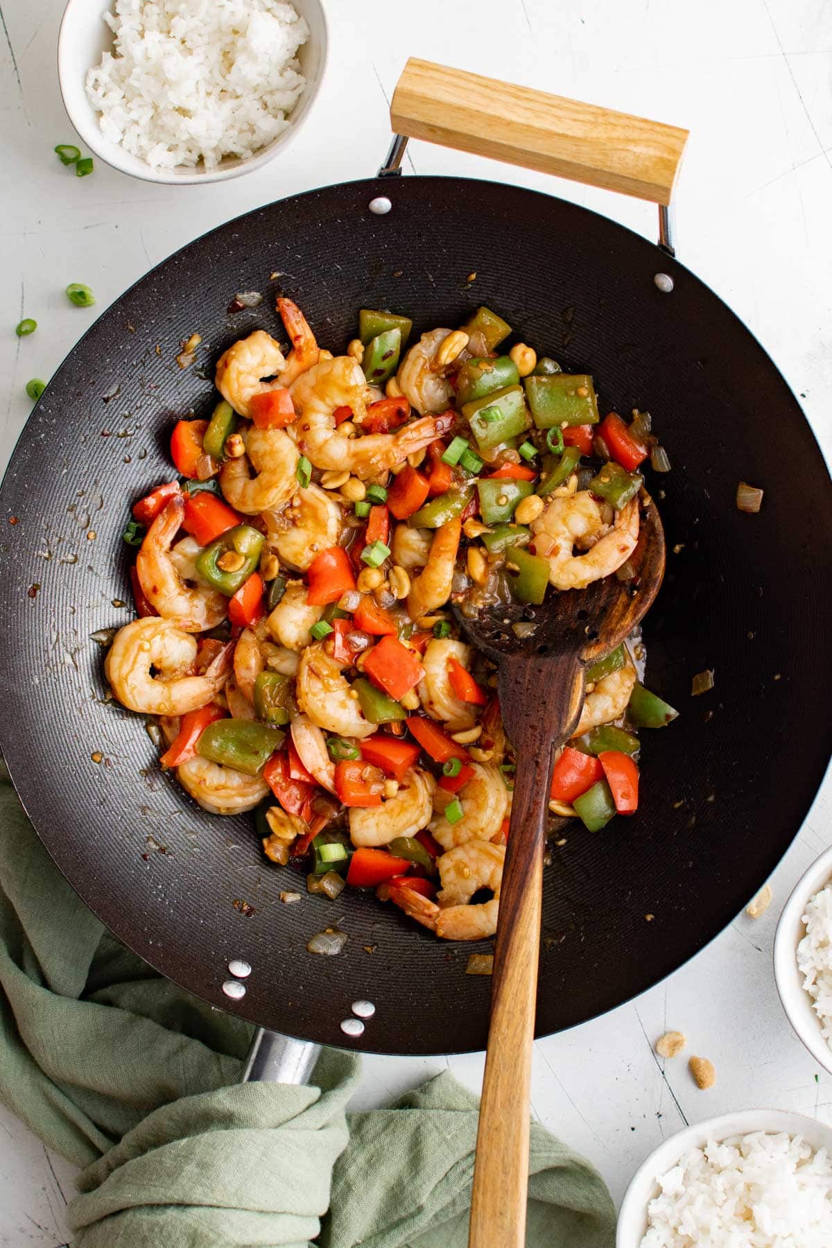 Kung Pao Shrimp in a wok with a wooden spoon.