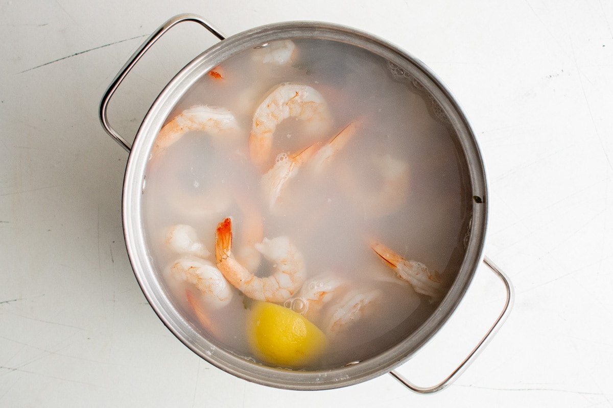 Soup pot with hot water and cooked shrimp.