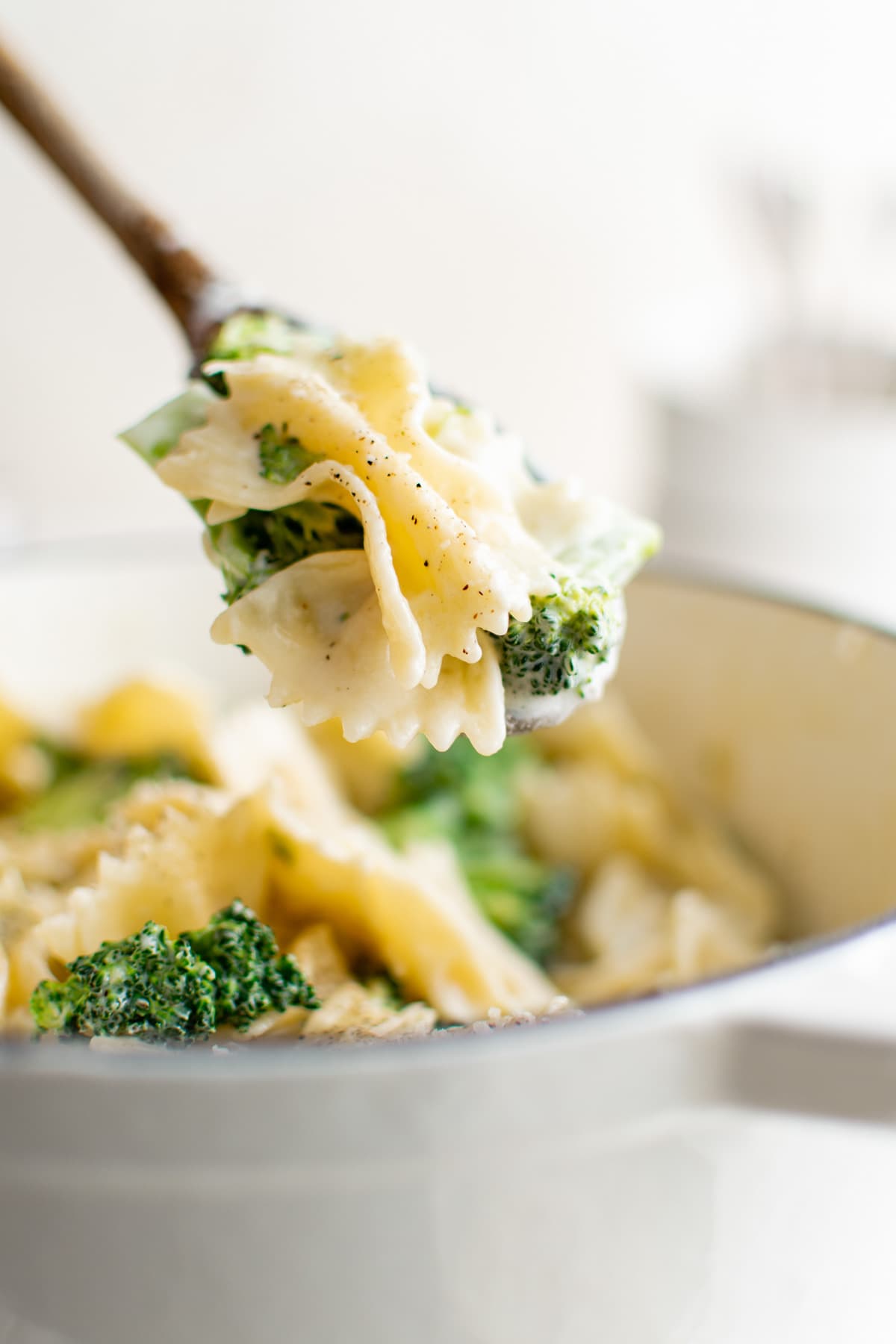 Pasta and broccoli serving on a wooden spoon.