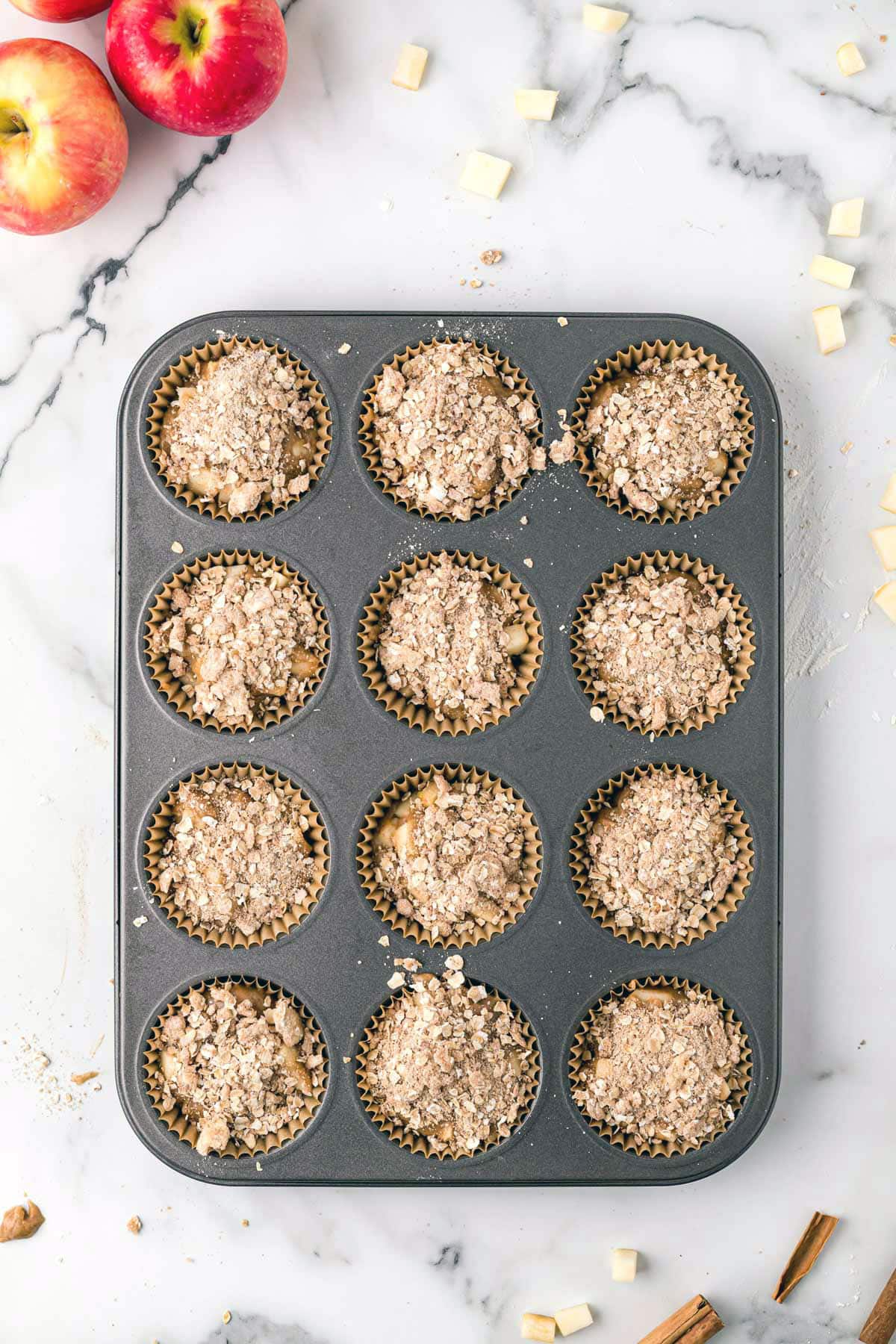 Apple cinnamon muffins batter in muffin cups.