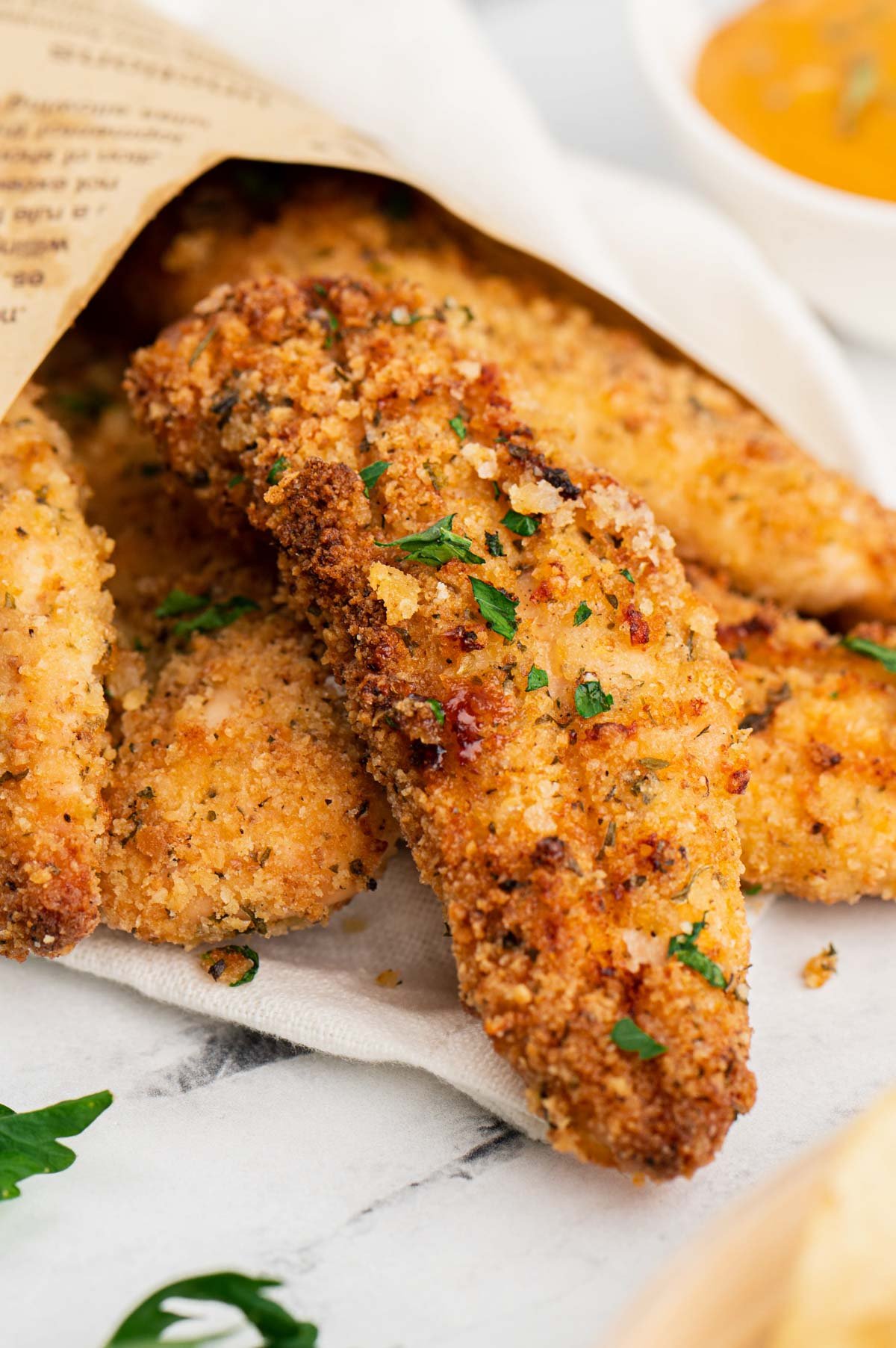 Baked Panko Chicken Tenders wrapped in newspaper.