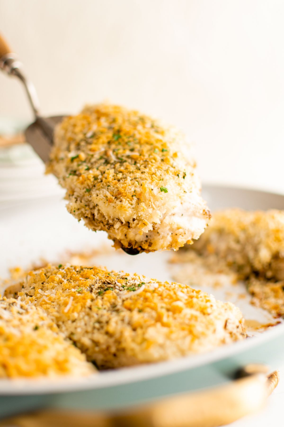 Chicken breasts with breadcrumb topping, spatula.