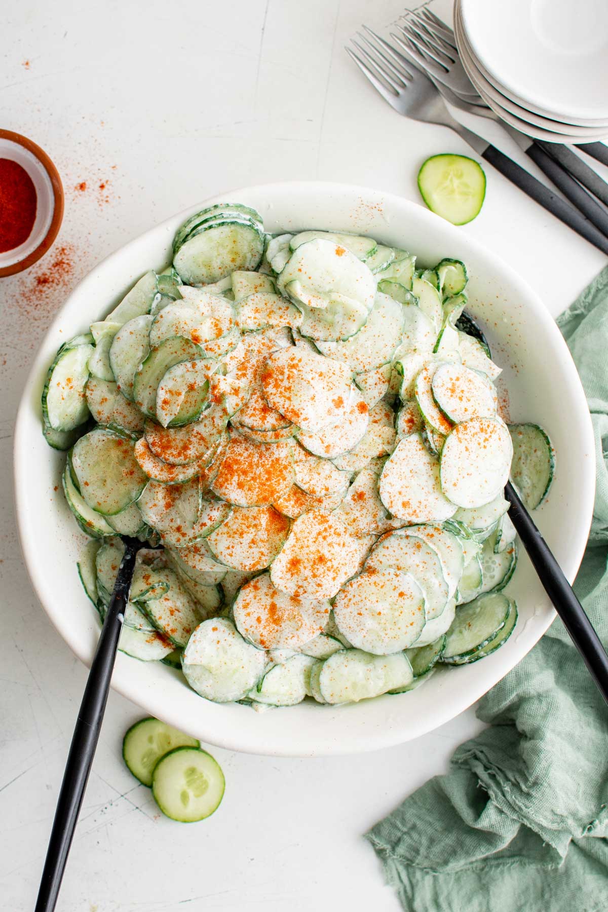Gurkensalat (cucumber salad) in a large serving bowl with two spoons.