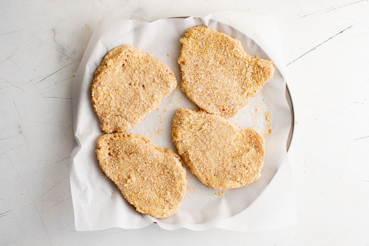 Breaded pork chops on a plate.