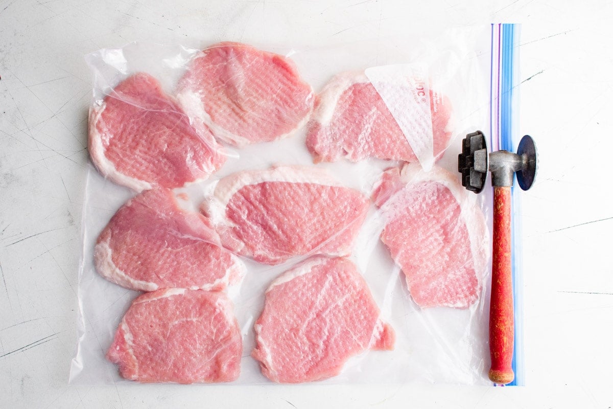 Pork chops in a plastic bag, pounded with a mallet.  