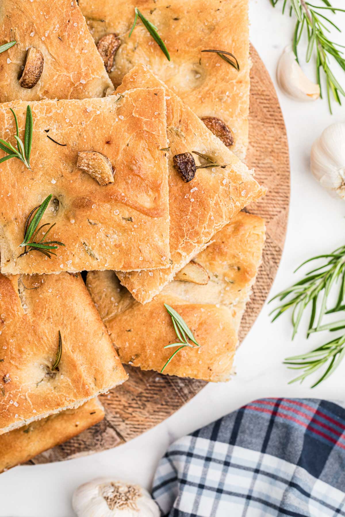 Close up overhead view of square of focaccia bread on a wooden tray. 