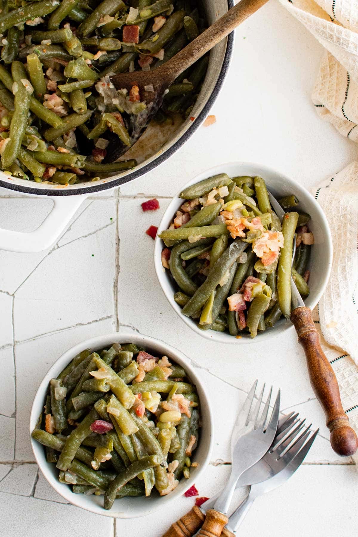 Two small bowls of Southern Style Green Beans, forks and a large pot.